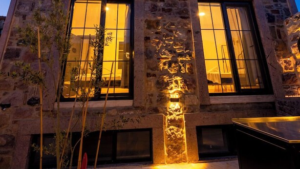 Un immeuble à plusieurs étages, doté d’une façade en pierre, de balcons et de grandes fenêtres.