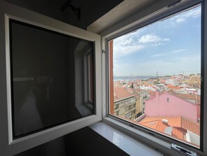 Une fenêtre donnant sur un paysage urbain, avec des bâtiments et un pont.