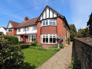 A two-story house with a garden, a pathway, and a brick wall. - 16 High Street (Scarborough)