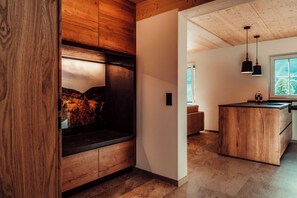 A modern kitchen with wooden cabinetry, a built-in island, and pendant lighting. - Forestum - Black Forest Luxury Apartments - Apartment Rothirsch with sauna (Sankt Blasien)