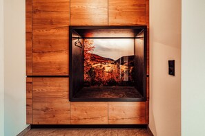 An elevator with a wooden panel design and a view of a landscape through the glass. - Forestum - Black Forest Luxury Apartments - Apartment Rothirsch with sauna (Sankt Blasien)