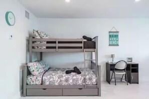 A bunk bed with a desk and chair, a clock, and a wall sign. - The Purple Pelican~Beachfront w/ Ocean Balcony~#5 (Fort Lauderdale)
