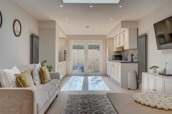 A modern kitchen with white cabinets, a built-in oven, and a microwave.