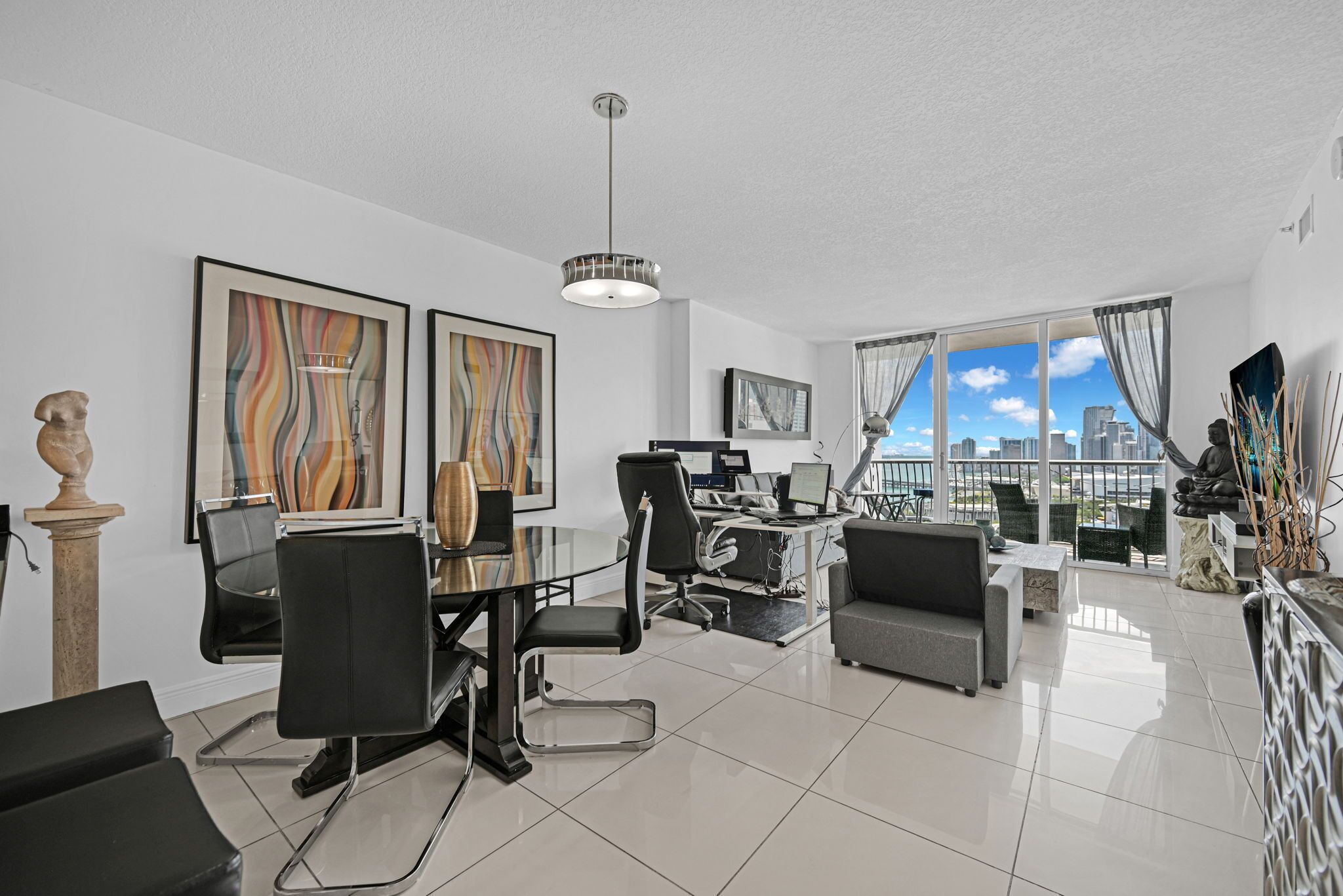 A modern living room with a dining area, a large window with a city view, and a ceiling light.