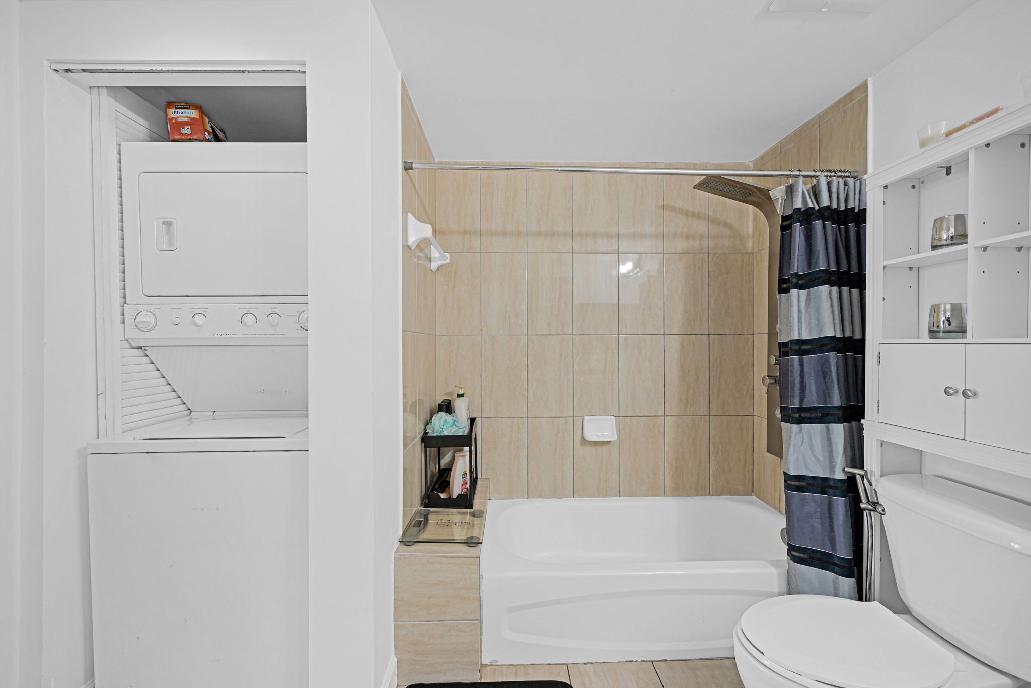 A bathroom with a bathtub, toilet, and shower area.
