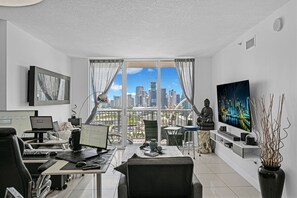 Ein modernes Büro mit Blick auf die Stadt, ein Schreibtisch mit Computer, ein Stuhl und eine Statue.