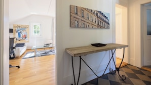 A modern living room with a sofa, coffee table, and a painting of buildings on the wall. - Art Apartments Bern (Bern)