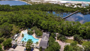 Luchtbeeld van een resort met een zwembad, een brug over het water en een strand.