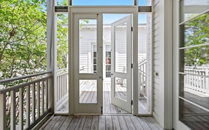 A wooden deck with a white door leading to a covered porch. - NEW Unique Seaside Gem with Gulf Views, Across from Pool, and 1 Block to Beach (Santa Rosa Beach)