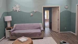 A room with a bed, a lamp, a starfish decoration, and a door leading to another room. - Quiet Calabash neighborhood convenient to everything (Calabash)