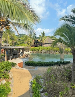 A resort with a pool, outdoor seating, and tropical vegetation. - Oceanview Suite Perfect Hideaway for Two (La Majahua)