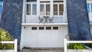 A two-story building with a balcony, a garage, and a brick facade. - Apartment 50 m from the Beach (Audierne)