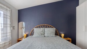 A bedroom with a bed, two bedside lamps, a wardrobe, and a window with curtains. - Apartment 50 m from the Beach (Audierne)