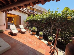 Un espace patio aménagé avec des chaises longues et des plantes en pot.