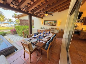 An outdoor dining area with a wooden table set for six, surrounded by cushioned chairs. - El lujo de una estancia sin fricción Playa Blancac (Playa Blanca)