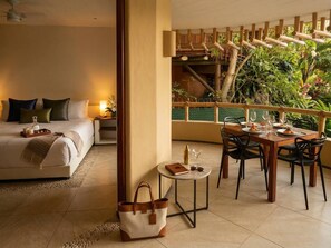 Ein Hotelzimmer mit einem Bett, einem Nachttisch und einem Essbereich mit Stühlen und einem Tisch.