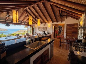A kitchen with a large island, a sink, and a view of the ocean. - Adults only Luxe 3br La Ropa Oasis w/ ccean view (Zihuatanejo)