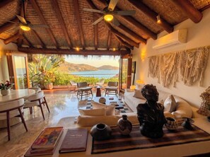 A spacious living area with a view of the sea, a dining area, and a seating area with a statue. - Adults only Luxe 3br La Ropa Oasis w/ ccean view (Zihuatanejo)