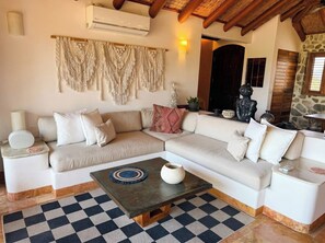 A modern living room with a sectional sofa, a coffee table, and a macrame wall hanging. - Adults only Luxe 3br La Ropa Oasis w/ ccean view (Zihuatanejo)