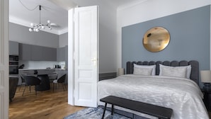 Un dormitorio con cama, mesita de noche y un espejo redondo en la pared.