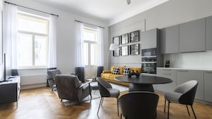 Un espacio habitable moderno con comedor, sofá y cocina.