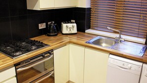 A compact kitchen with a gas stove, toaster, sink, and dishwasher. - Comfortable, modern 2 bed apartment in the heart of the Old Town (Hemel Hempstead)