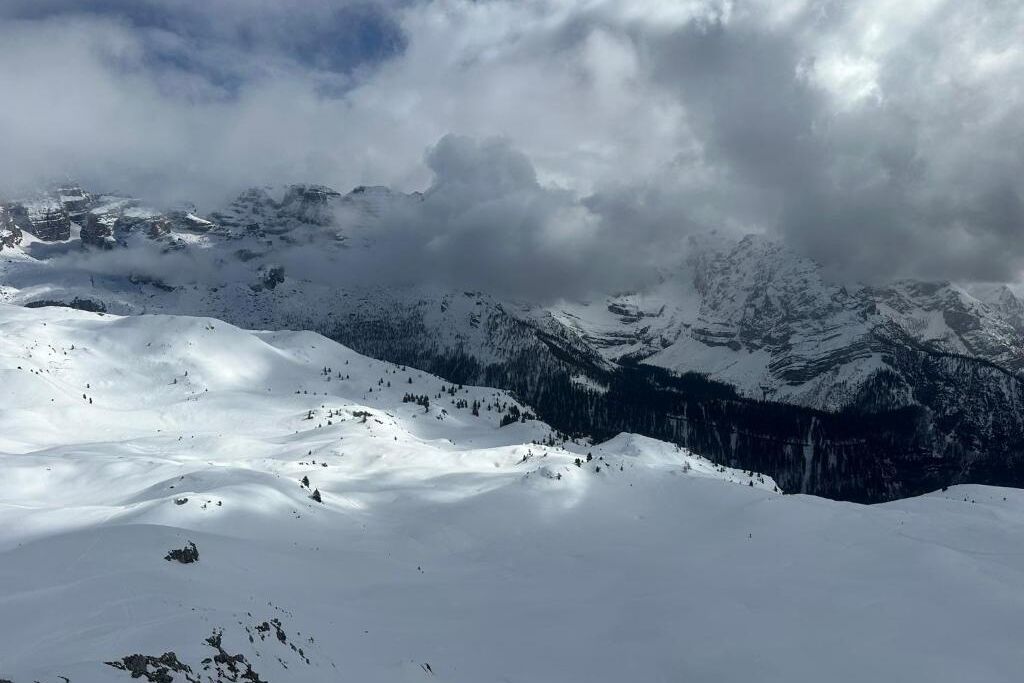 Un paysage montagneux enneigé, avec une vallée et des sommets lointains.