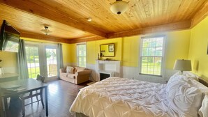 A room with a bed, a desk, a chair, a sofa, and a fireplace.