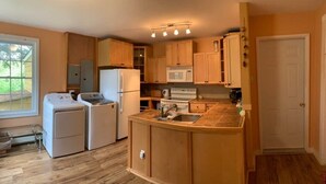 A kitchen with wooden cabinets, a built-in oven, a microwave, and a sink.
