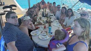Un grupo de personas cenando en un barco con vistas al mar.