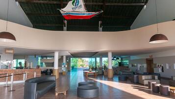 Um hall amplo com balcão de recepção, áreas de estar e uma grande decoração de veleiro.