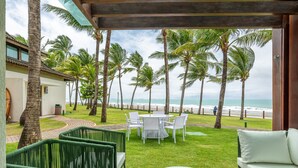 An outdoor seating area with a view of the ocean, surrounded by palm trees and a covered patio. - BeachClass Muro Alto Porto de Galinhas (Ipojuca)