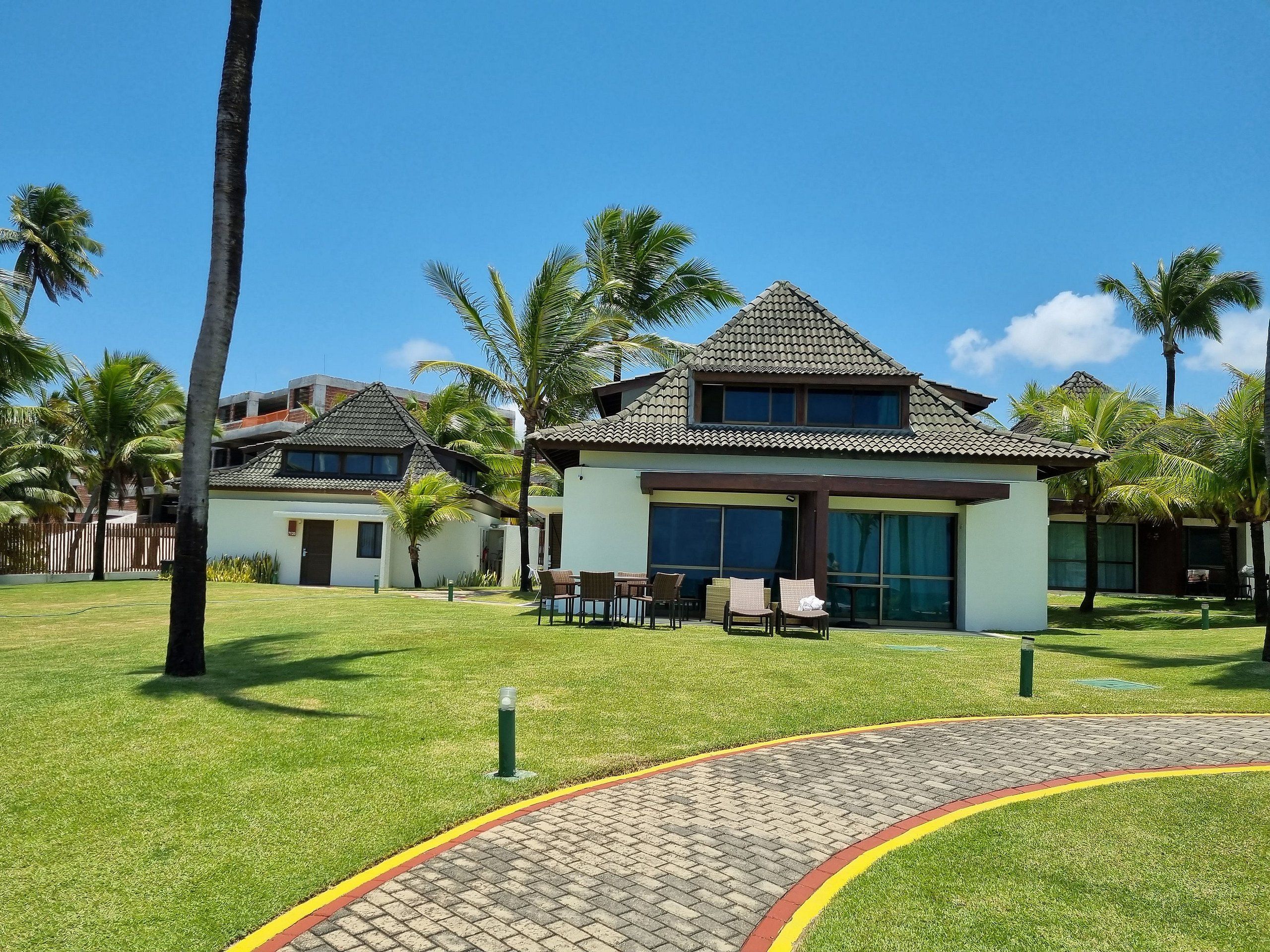 Ein Resort mit mehreren Gebäuden, Außenbereich und Palmen.