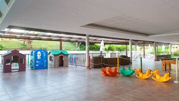 An indoor play area with various play structures and a tiled floor.