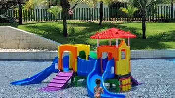 A water play area with slides and a small red-roofed structure.