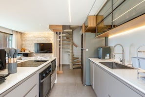 Una cocina moderna con horno empotrado, refrigerador y pileta.