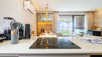 A modern kitchen with a built-in induction cooktop, a blender, and a coffee maker.