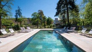 A rectangular swimming pool with clear water, surrounded by white lounge chairs and a paved deck. - La Petite Cabane (Saint-Affrique)