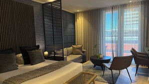 A modern hotel room with a large bed, a sofa, a dining area, and a balcony with curtains. - Cape Town Studio 16 on Bree (Cape Town)