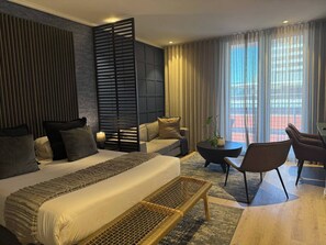 A modern hotel room with a large bed, a sofa, a dining area, and a balcony with curtains. - Cape Town Studio 16 on Bree (Cape Town)