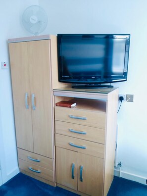 A wooden wardrobe with multiple drawers and a television on top. - The Beeches Hotel (Blackpool)