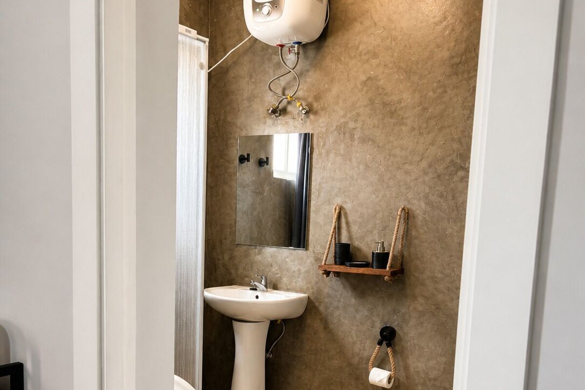 Un baño con inodoro, lavamanos y toallero.