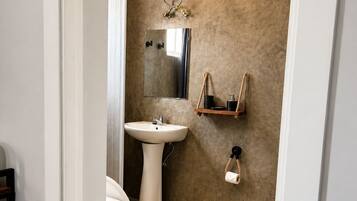Une salle de bain avec des toilettes, un lavabo et un porte-serviettes.