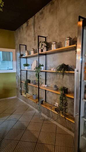 Una pared con múltiples estantes que exhiben plantas y adornos.