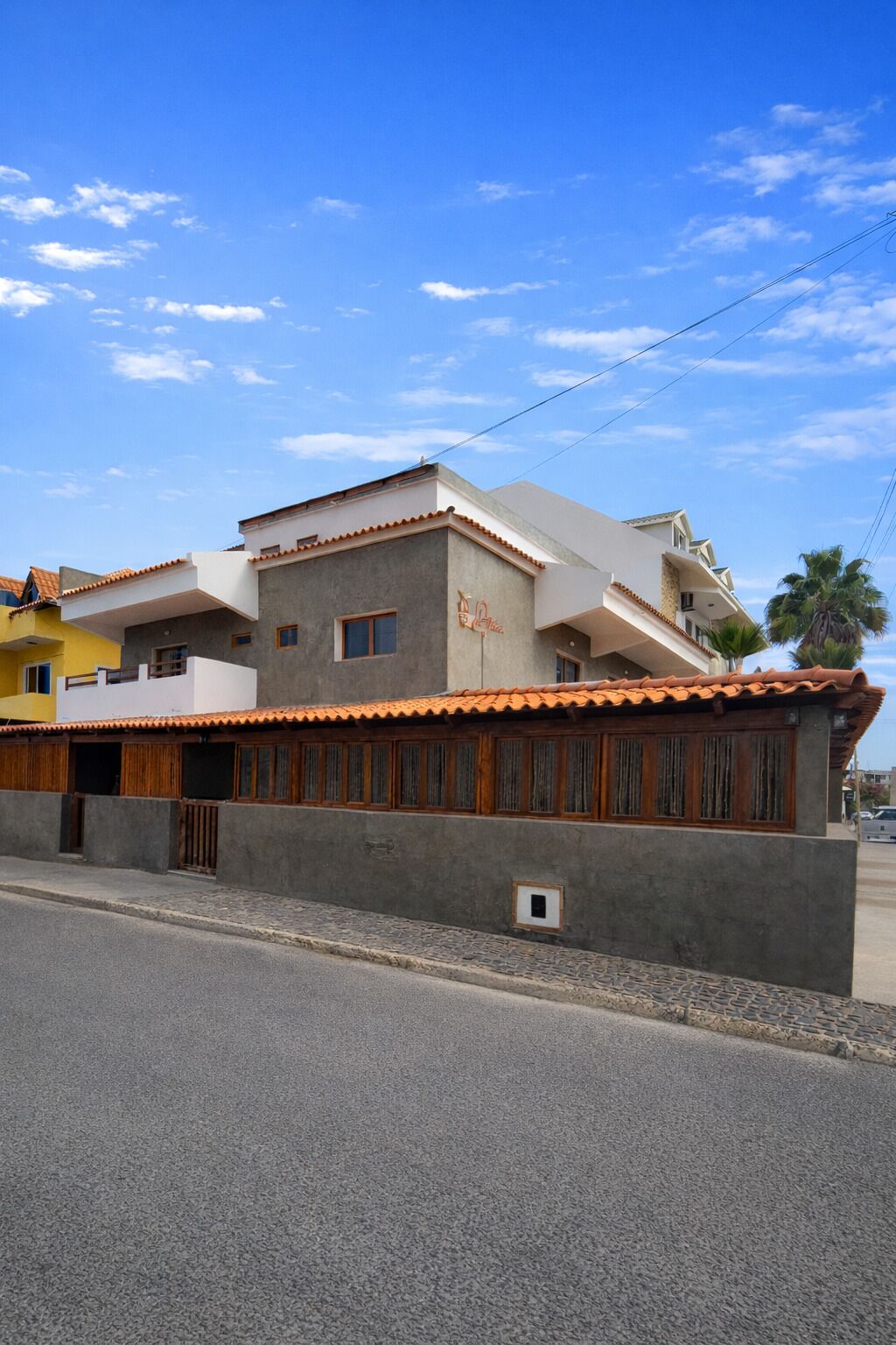 Un edificio residencial con techo de tejas, un balcón y una ventana pequeña.