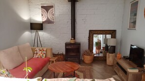 Ein Wohnzimmer mit einer Couch, einem Couchtisch, einem Kamin, einem Fernseher und einem Spiegel.