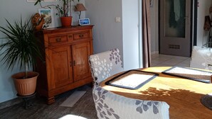 Ein Essbereich mit Holztisch, Stühlen, einem Schrank und einem Blumentopf.