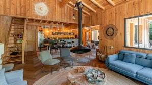 A wooden interior with a dining area, kitchen, and seating space. - Villa Yucca - Cap Ferret *Heated pool *Market *Beaches (Lège-Cap-Ferret)