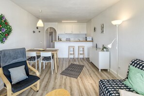 A compact living space with a dining area, kitchenette, and seating area. - Apartment 'Salins 5' with Sea View, Wi-Fi and Air Conditioning (Empuriabrava)