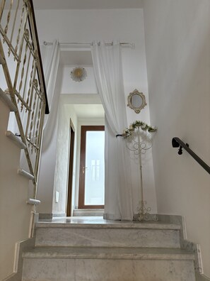A staircase with white curtains, a decorative mirror, and a floor lamp. - Villa del Sognatore, tuscan villa with pool for 12 (Careggia)